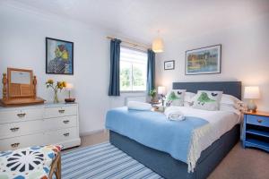 锡德茅斯Orchard Cottage的一间卧室配有一张床、一个梳妆台和一扇窗户。