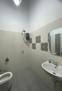 Kampong Bukit KatilTraditional Melaka Homestay with Private Pool的一间带水槽、卫生间和镜子的浴室