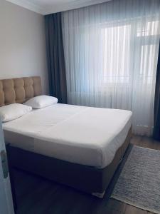 KumbağThe Rooms Boutique Otel的卧室内的一张床铺,设有大窗户