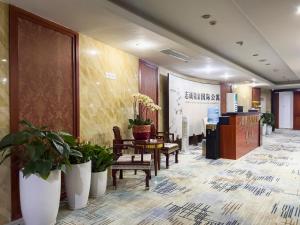 广州广州志诚领游国际公寓的大堂设有桌椅和盆栽植物