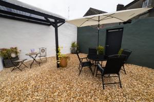 比尔4 Connaught Street Birr的庭院配有桌椅和遮阳伞。