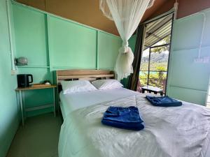 皮皮岛Phi Phi Seaside Bungalow的一间卧室配有一张带2条蓝色毛巾的床