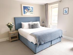 道格拉斯Sail Lofts的一间卧室设有蓝色的床和窗户。