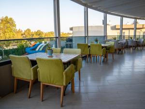 居姆贝特博德鲁姆海滨度假酒店的阳台的用餐室配有桌椅