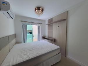 邦巴斯Apartamento a 60m da praia de Bombas的卧室配有白色的床和窗户。