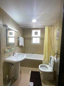 迪拜Marbella Holiday Homes - Al Nahda 2BHK的浴室配有盥洗盆、卫生间和浴缸。