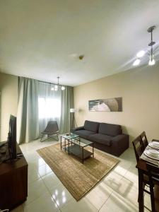 迪拜Marbella Holiday Homes - Al Nahda 2BHK的客厅配有沙发和桌子
