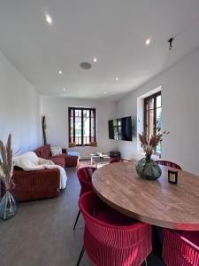 萨尔拉拉卡内达Maison de ville Duplex Artienzo的客厅配有桌子和红色椅子