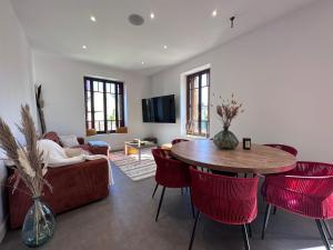 萨尔拉拉卡内达Maison de ville Duplex Artienzo的客厅配有桌子和红色椅子