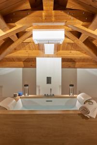 拉默齐亚泰尔默Relais - Palazzo Greco Stella的配有木制天花板的客房内的浴缸
