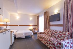 孔布卢Les Aiguilles De Warens的酒店客房设有一张沙发和一张床