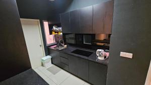 加影Serenestay Cozy Studio @ Southville City的一间小厨房,配有黑色橱柜和水槽
