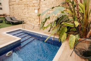赫雷斯-德拉弗龙特拉Astuto Boutique Jerez - Adults Only的植物繁茂的庭院中间的游泳池