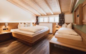 雷滕贝格Gsolhof的配有木墙和木地板的客房中的两张床
