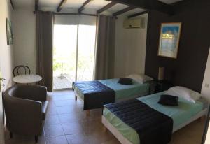 ErbajoloGîtes et Astrotourisme en Corse的客房设有两张床、一把椅子和窗户。