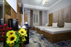 TürkistanAlmaty City的一间酒店客房,配有两张床和鲜花