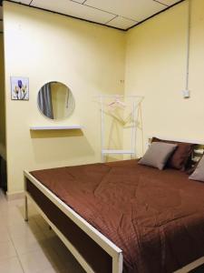 珍南海滩Lagenda Resthouse Langkawi的一间卧室配有一张带镜子的大床