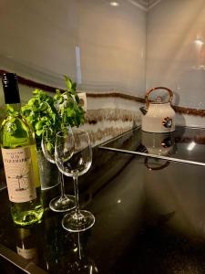 奥伯古格尔Apartment Gletscherbergblick的柜台上的一瓶葡萄酒和两杯酒