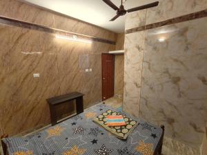 马尼帕尔Guest Nest的客房设有桌子和玻璃淋浴间。