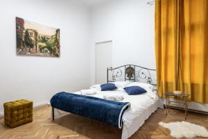 克卢日-纳波卡Royal 5* mansion near central square的一间卧室配有一张带蓝色枕头的床