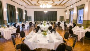 纳克斯考Hotel Harmonien的宴会厅配有桌椅和白色的桌布