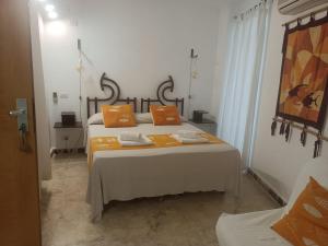 蓬扎Piccolo Hotel Luisa的一间卧室配有两张带橙色枕头的床