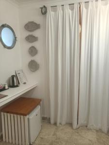 蓬扎Piccolo Hotel Luisa的浴室设有白色的淋浴帘和镜子