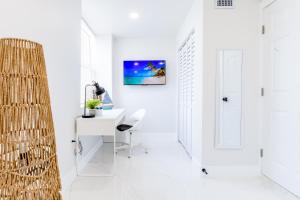 迈阿密Serenity Lodge Condo的白色的客房设有书桌和墙上的电视