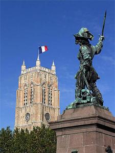 敦刻尔克Appartement Dunkerque的塔前有旗帜的雕像