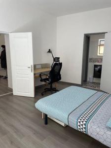维希La Maison de Guilaine的客房设有一张床、一张桌子和一把椅子。