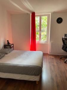 维希La Maison de Guilaine的一间卧室配有一张带红色窗帘的床和窗户