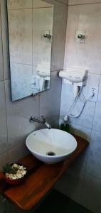 戈亚斯州上帕莱索Pousada Sertão的浴室设有白色水槽和镜子