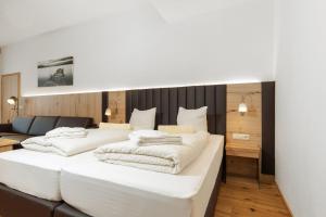 巴德哥依斯恩Appartementhaus Dachsteinblick mit Indoorpool und Sauna的一间带两张白色床和一张沙发的卧室