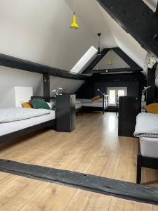 卢布尔雅那Sax Pub Hostel Ljubljana的阁楼卧室设有两张床,铺有木地板。