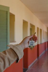 科连特斯Alojamiento en pleno centro de Corrientes的手持门钥匙的人在走廊