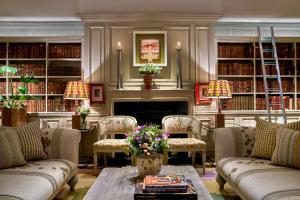 伦敦索霍菲尔姆戴尔酒店的客厅配有沙发,图书馆设有壁炉
