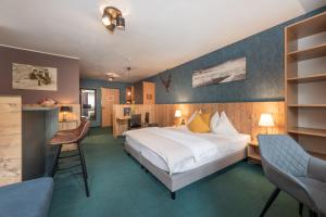 东蒂罗尔地区马特赖AlpenParks Hotel MONTANA的酒店客房,配有一张床、一张桌子和椅子