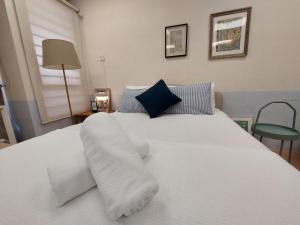 普崇Starman's Gem by Inspired Homes, 4Pax的白色的床,配有白色床单和蓝色枕头