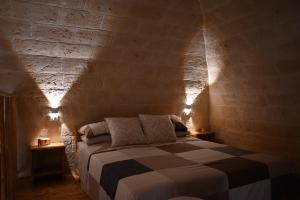 卡诺萨迪普利亚Faliero Room的卧室配有砖墙内的床铺