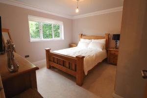 柯金蒂洛赫Woodhead view的一间卧室设有一张木床和一个窗户。