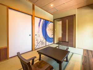 加贺LiVEMAX RESORT Kaga Yamashiro的客房设有桌椅和窗户。