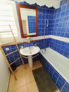 拜马欧les Aliceas appartement cosy的蓝色瓷砖浴室设有水槽和浴缸