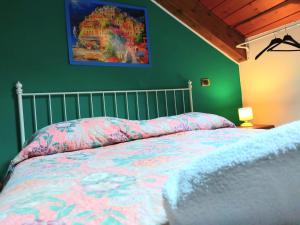 阿杰罗拉La Locanda del Pettirosso的卧室配有一张床,墙上挂有绘画作品