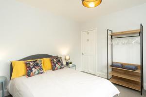 莱斯特Stratford House的一间卧室配有白色床和黄色枕头
