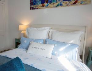 亨斯坦顿Avocet House Hunstanton 250m from the sea的一张带蓝色和白色枕头的床和良好的夜间枕头