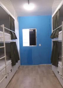 若昂佩索阿GVR Praia Hostel的客房设有两张双层床和蓝色的墙壁。