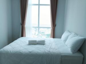 名古屋Formosa Spacious Apartments with Netflix & Free Shuttle by MESA的窗户客房内的一张白色床