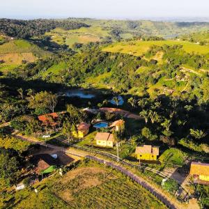 巴纳内拉斯Chalés Samambaia的享有小山和河流上村庄的空中景色