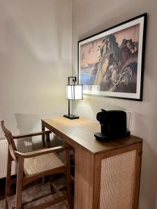温彻斯特Kyoto Rooms Winchester的一张桌子,里面配有一盏灯和一把椅子