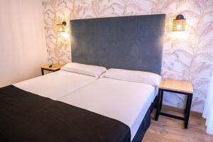 卡米诺新村Complejo Roma的一间卧室配有一张带白色床单的大床